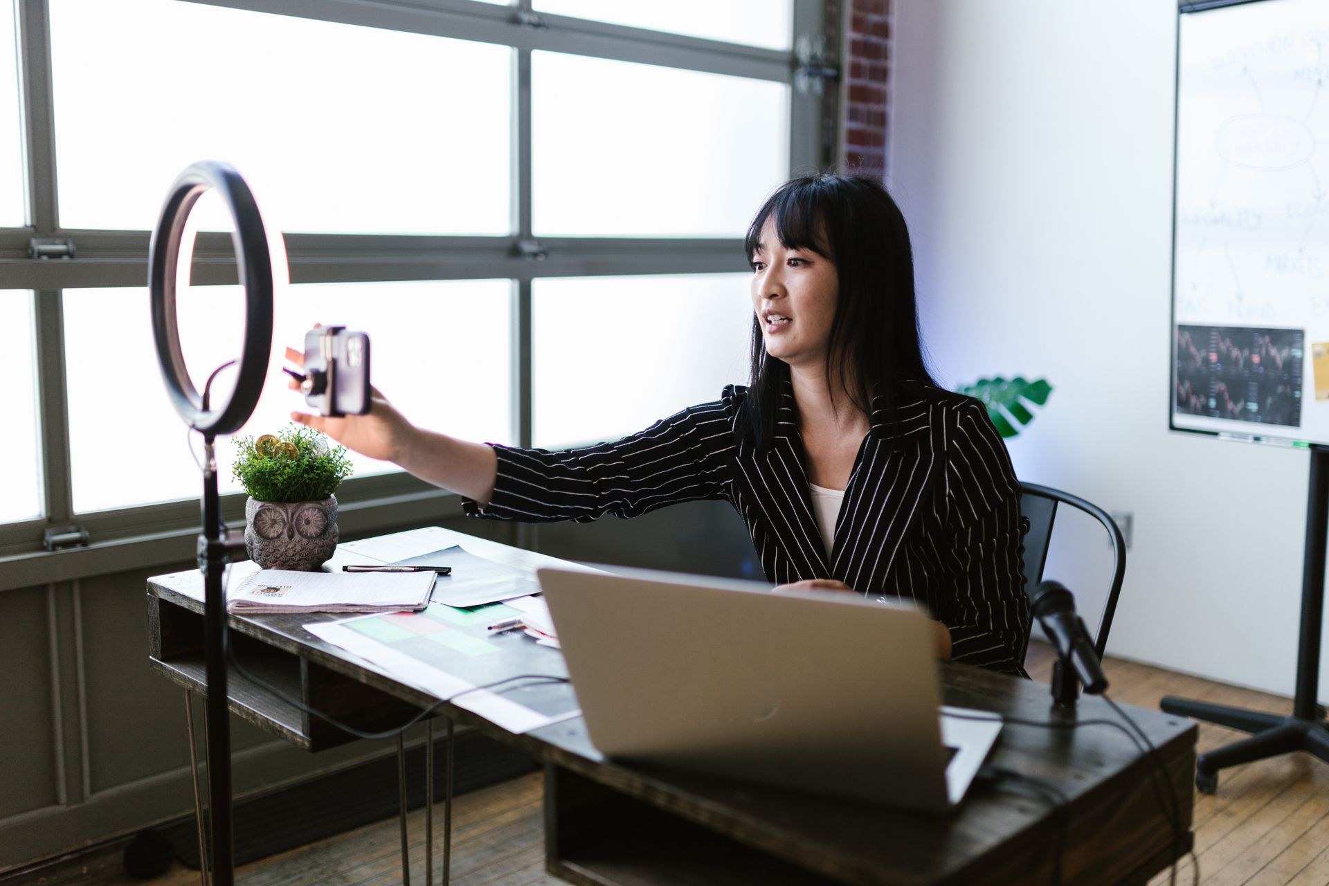 Creator filming a video at a desk with a ring light and smartphone