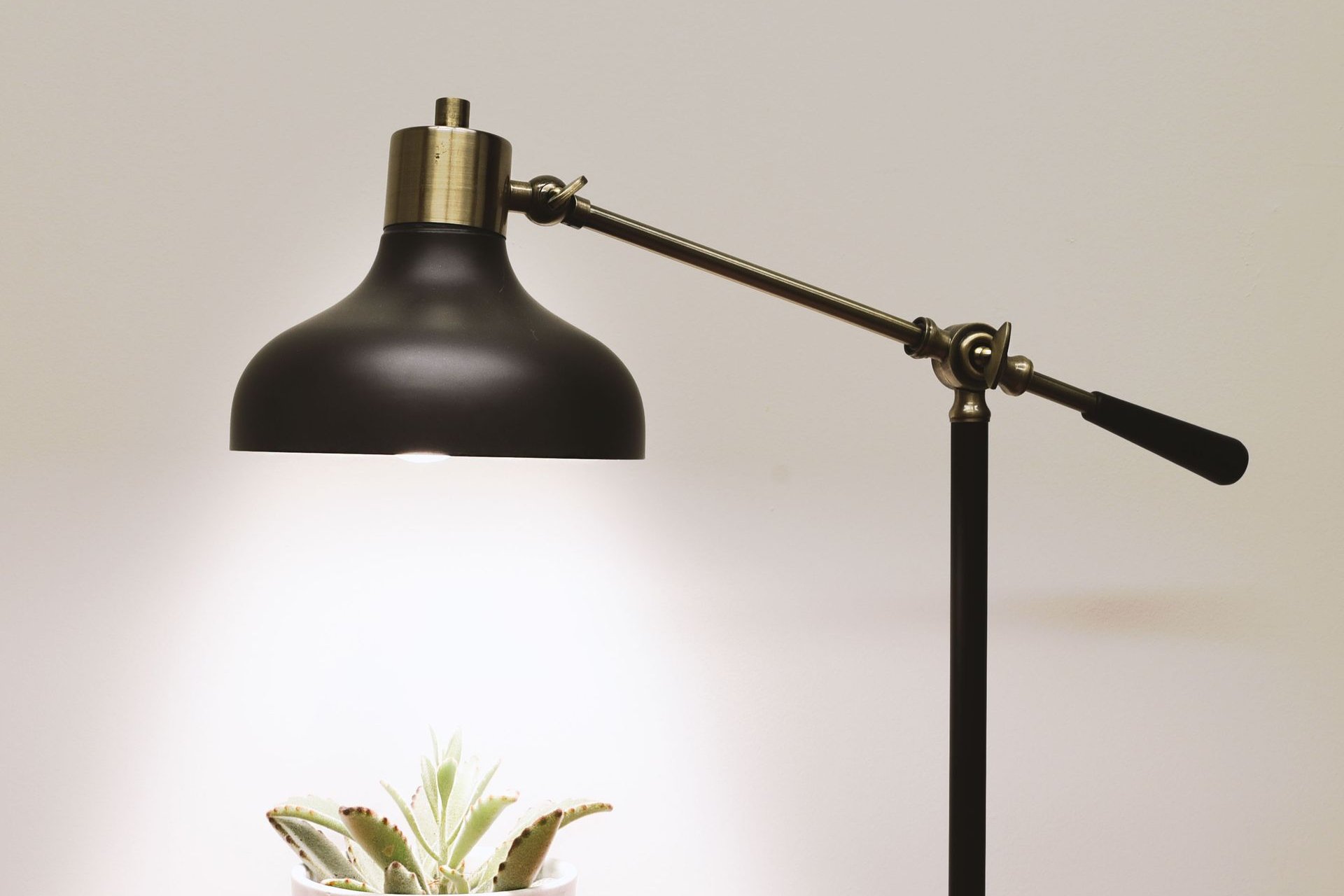 Modern swing-arm desk lamp lighting a home office desk