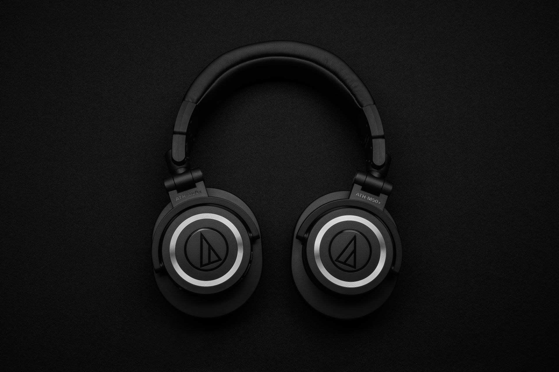 Black wireless headset against a dark background