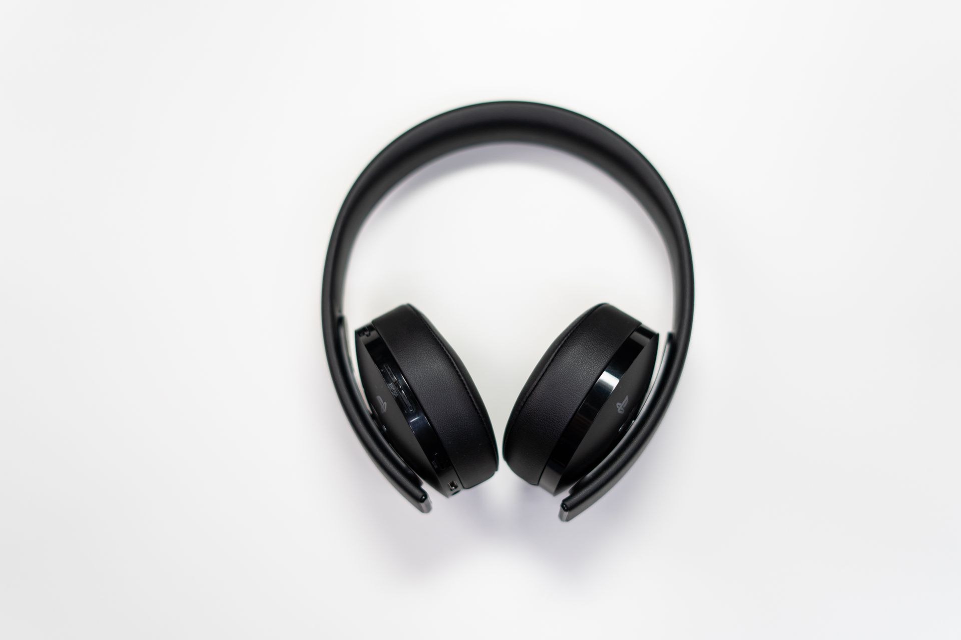 Black wireless headset, flat lay on a white desk